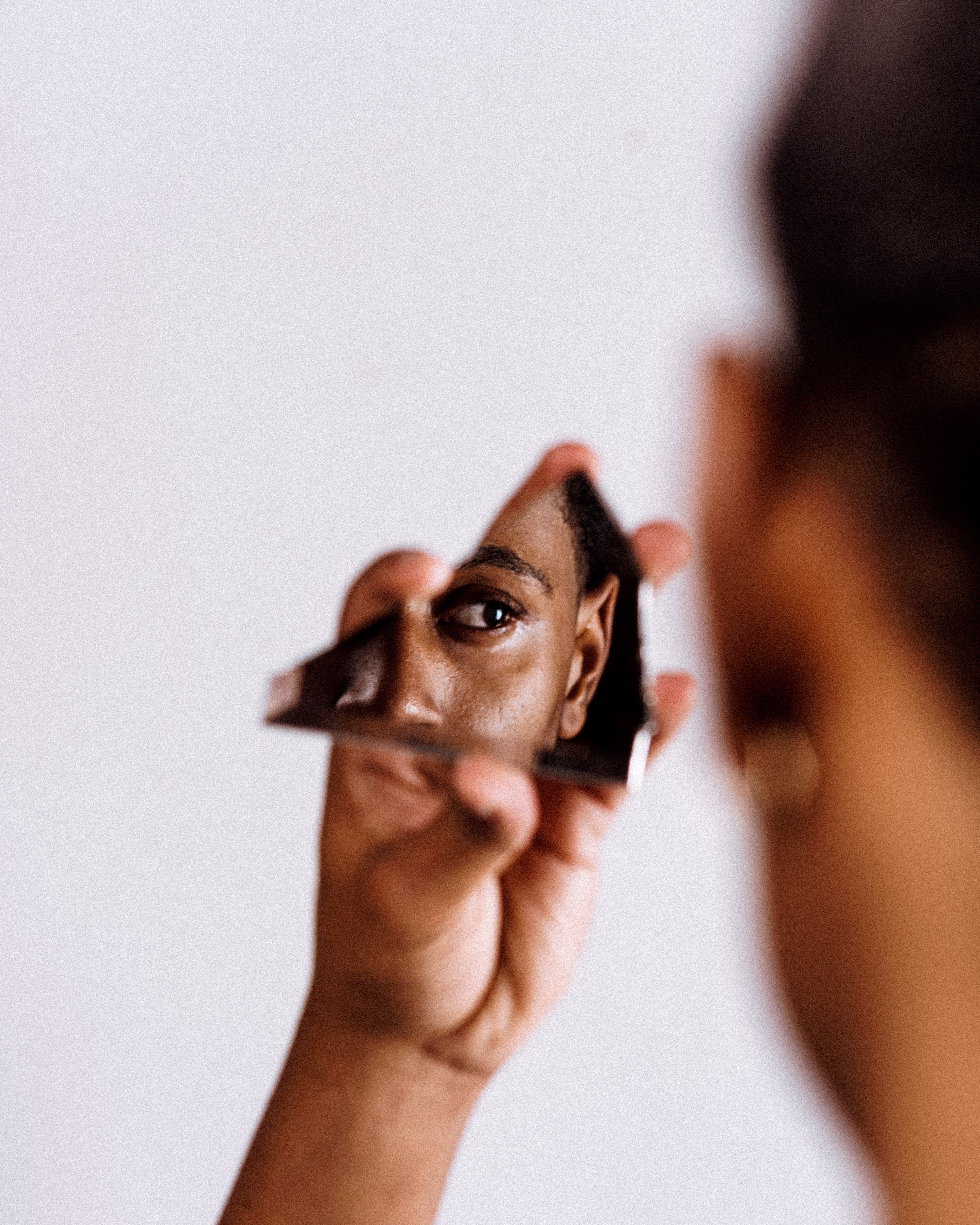 Une personne se regarde dans un miroir brisé 