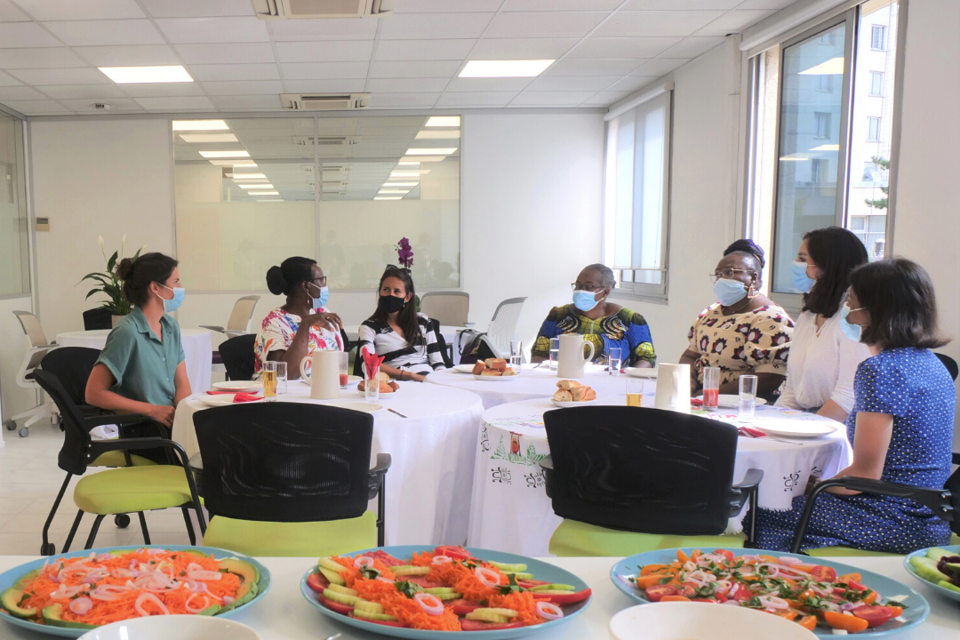 Des femmes sont assises autour d'une table et y partage un repas