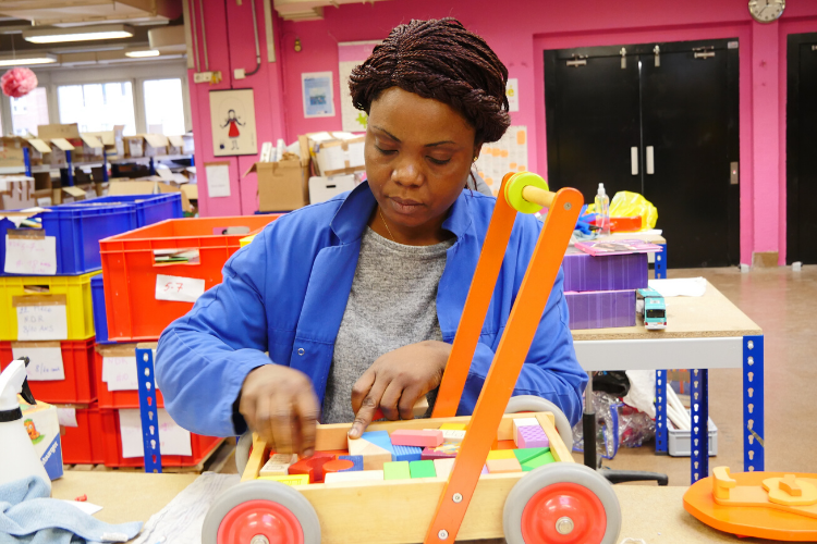 Emma, salariée en insertion de Rejoué, nettoie des jouets destinés au marché de l'occasion.