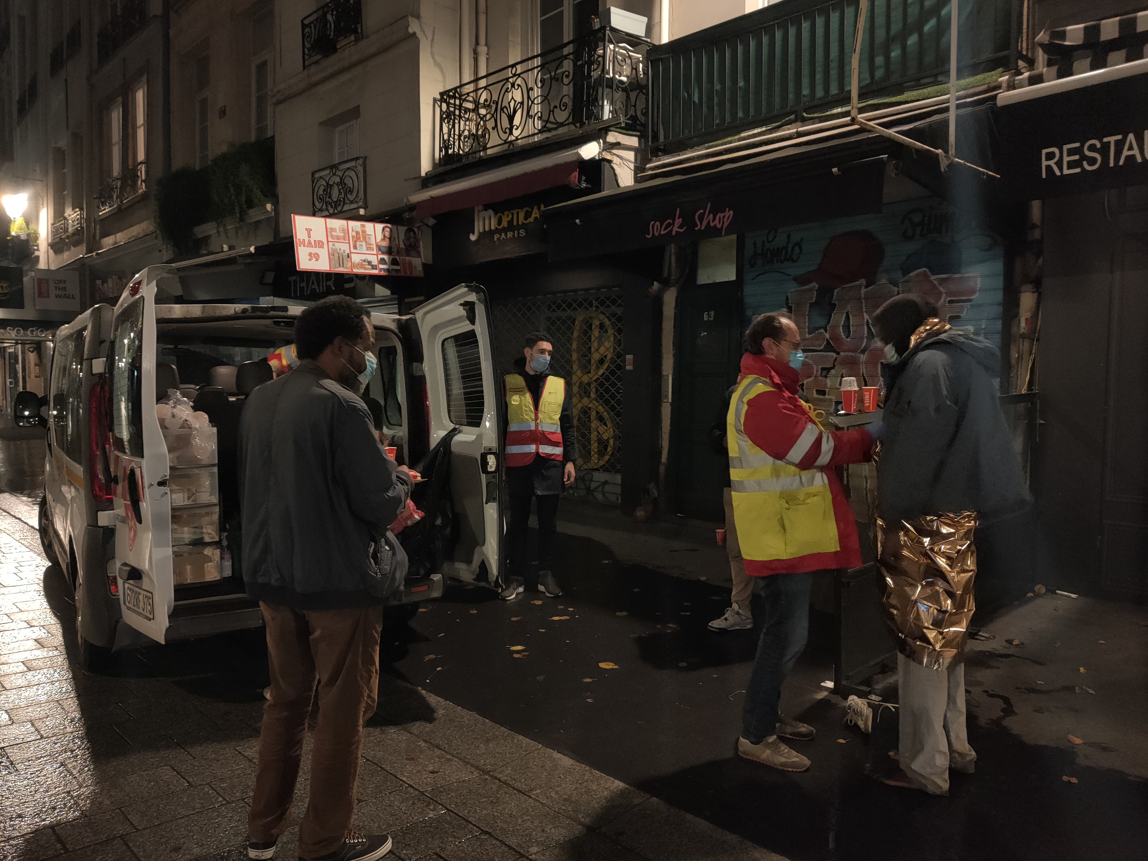 Cédric Chalret aide un homme à disposer une couverture de survie qui lui permettra de gagner quelques degrés. Crédit photo : Carenews.