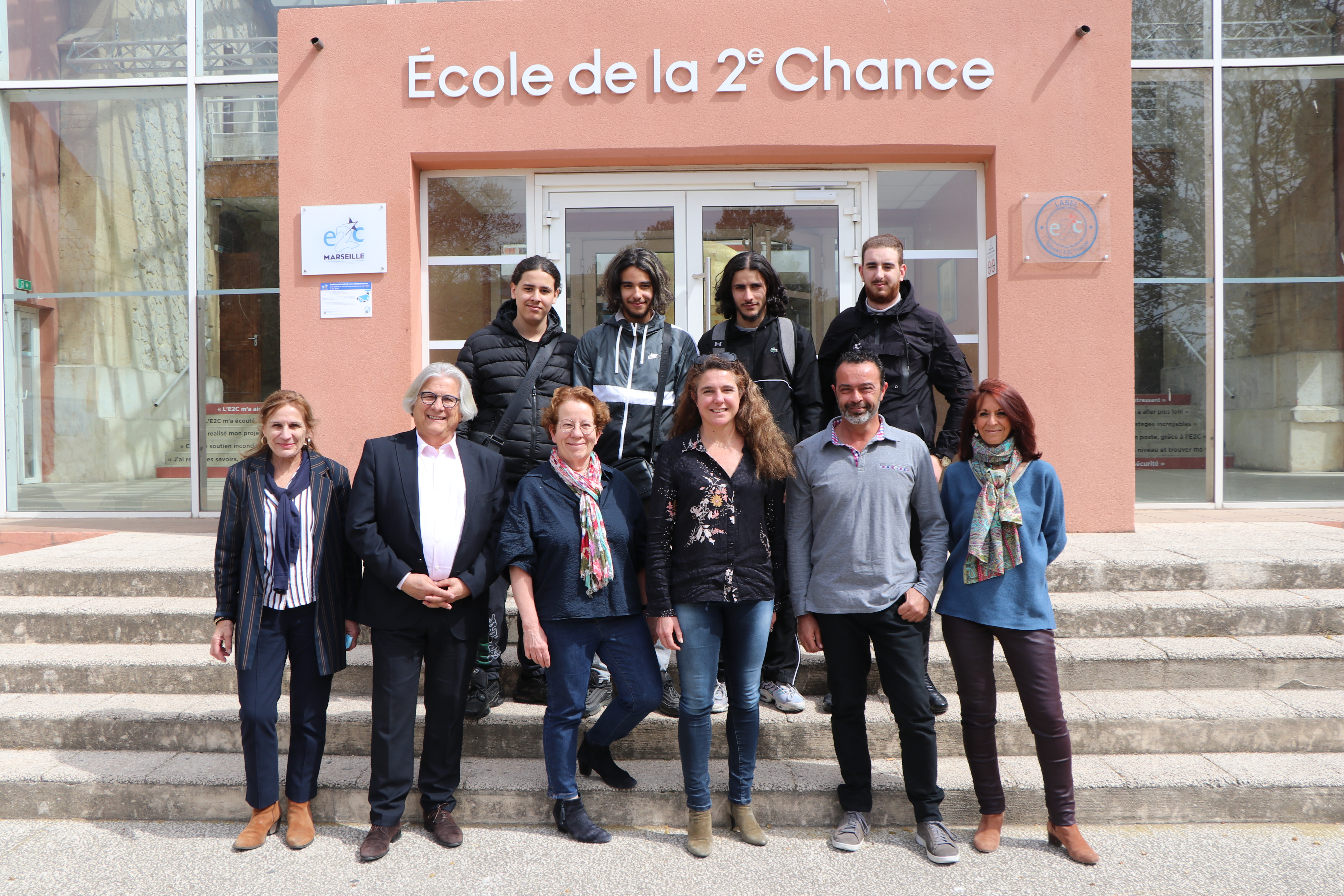Les représentants du groupe La Poste et de l'Ecole de la deuxième chance de Marseille devant l'entrée principale du campus