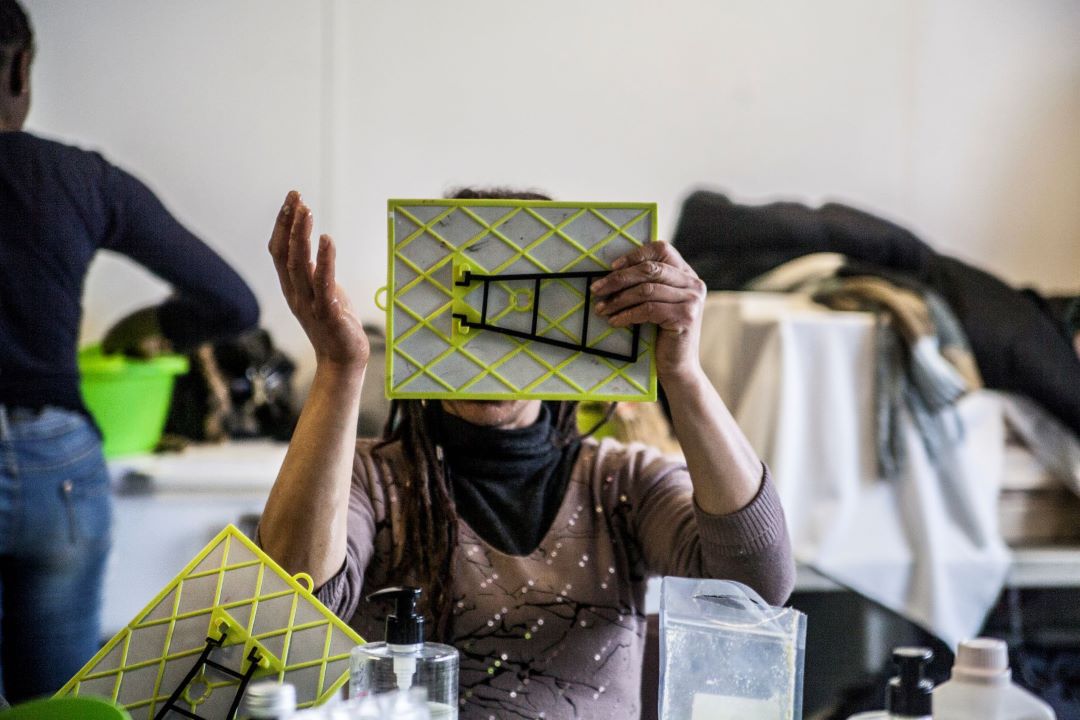 Une personne se regarde dans un miroir pendant une séance de socio-esthétique