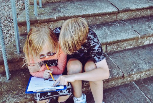 Deux enfants s'aidant sur un devoir