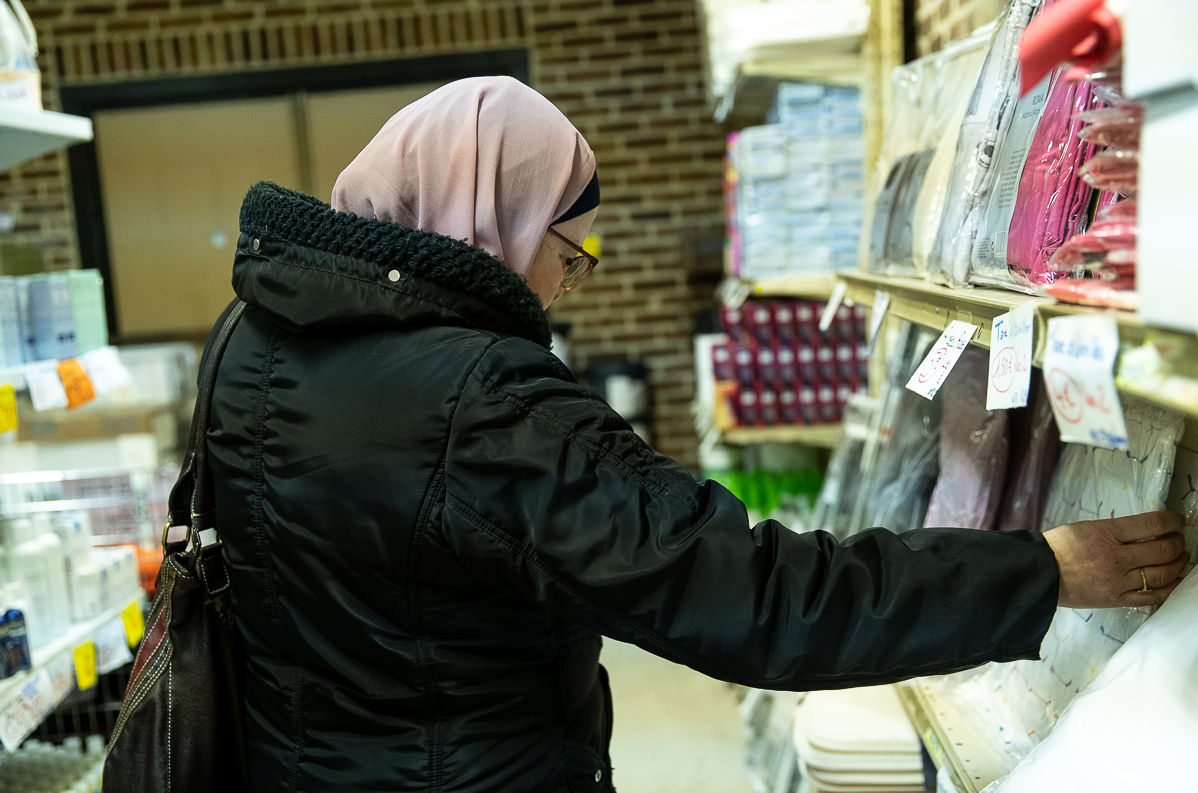 Femme prenant un produit dans le rayon d'une épicerie sociale et solidaire