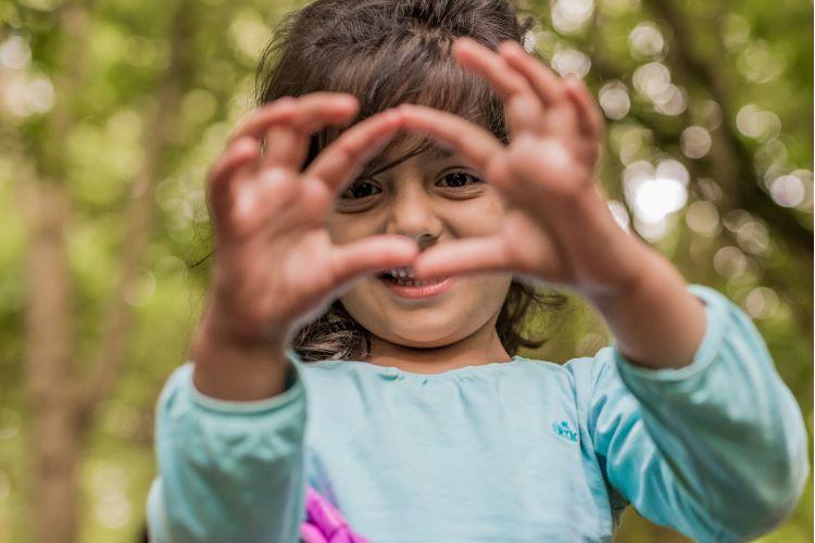 Petite fille faisant un coeur avec ses mains