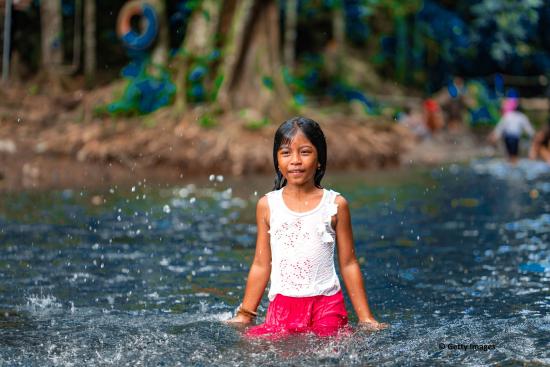 Petite fille jouant dans une rivière en Asie