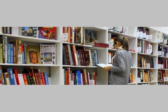Une personne dans les rayonnages d'une librairie