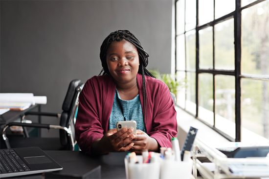 Une jeune femme, déficiente sensorielle, utilise un téléphone portable.