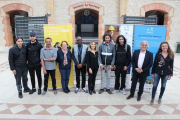 Les jeunes et les représentants de l'Ecole de la deuxième chance de Marseille posent aux côtés des représentants du Groupe La Poste dans le hall du campus de l'E2C
