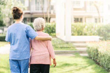 Une soignante accompagne une femme âgée. Crédit : iStock