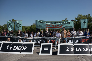 Le 25 mai, des dizaines de croyants bloquent un pont parisien pour protester contre le projet EACOP. © Clément Tissot/GreenFaith